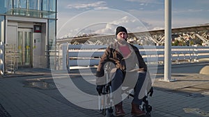 man with physical disability and paraplegia is moving by wheelchair in city