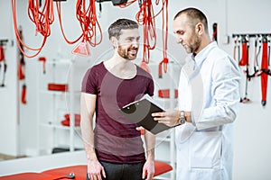 Man with physiotherapist at the rehabilitation office