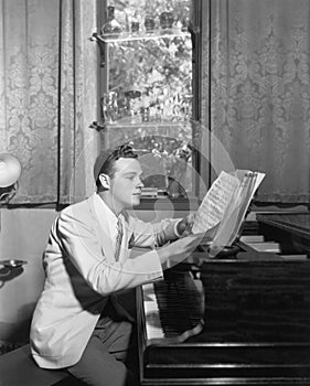 Man at piano with sheet music