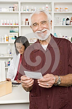 Man Picking Up Prescription Drugs At Pharmacy