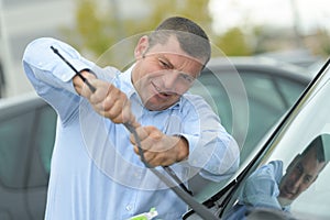 Man picking up windscreen wiper