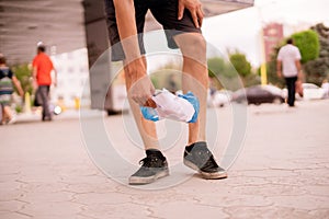 man picks the garbage plastic and paper in the city street. clean environment