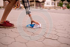 man picks the garbage plastic and paper in the city street. clean environment