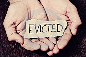 Man with a piece of paper with the word evicted photo