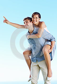 Man piggybacking woman. Portrait of handsome man giving piggyback ride to woman.
