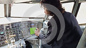 A man on a pilot seat is looking at the controls