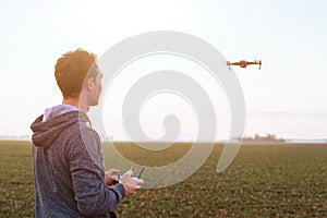 Man piloting drone at sunset