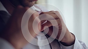 Man pinches buttons in shirt and loock to window, close up, slow motion handy camera motion style