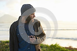 Man, pipe and thinking in nature by ocean for ideas, vision or planning on winter morning. Male person, sunrise and