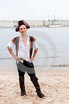 Man in pirate costume put his hands on his hips on the beach