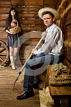 Man with pitchfork in straw hat woman with basket