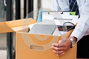 Man places personal items and resignation letter into a box, ending his tenure.