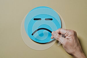 man places a sad mouth on a blue face