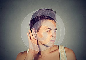 Man placing hand on ear listening carefully to gossip