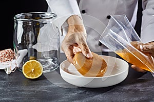 Man placing a scoby in a dish for activation photo