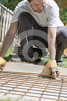 Man placing steel bars net in a hole as foundation