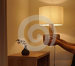 Man placing a table lamp in the corner