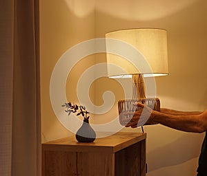 Man placing a table lamp in the corner