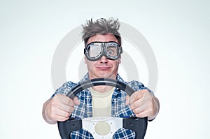 Man in plaid shirt and stylish goggles with steering wheel, front view. Car driver concept
