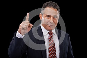 The man with a plan. Portrait of a businessman on a black background pointing upwards.