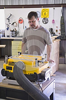 Man planing board with machine planer