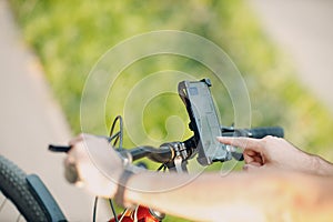 Man planning route using GPS navigation application in mobile phone on his bicycle bike.