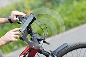 Man planning route using GPS navigation application in mobile phone on his bicycle bike.