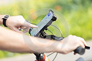 Man planning route using GPS navigation application in mobile phone on his bicycle bike.