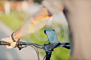 Man planning route using GPS navigation application in mobile phone on his bicycle bike.