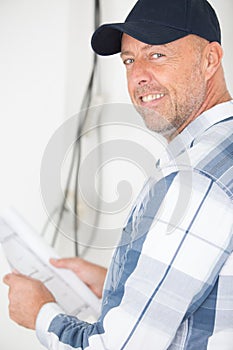 man with plans smiling at camera photo