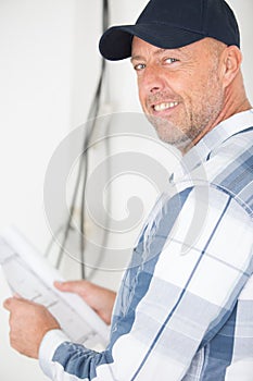 man with plans smiling at camera