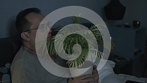 Man with plant watching scary movie