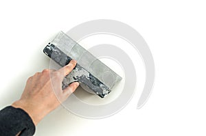 Man plastering the walls with finishing putty in the room with putty knife or spatula. Repair work, decoration building concept, c