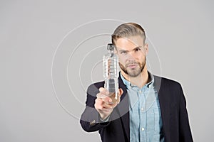 Man with plastic bottle on grey background, thirsty