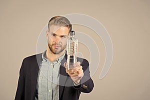 Man with plastic bottle on grey background, thirsty