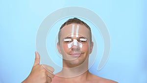 A man after a plastic surgery facelift, rhinoplasty, blepharoplasty. with a bandage on the nose, head and eyes. on blue