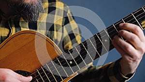 Man play acoustic guitar at blue wall