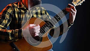 Man play acoustic guitar at blue wall