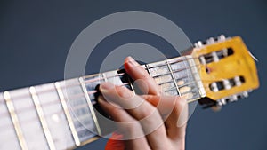 Man play acoustic guitar at blue wall closeup