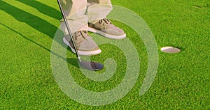 Man play Golfing And Putting Ball In Hole. Close-up.
