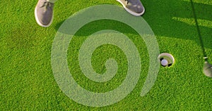 Man play Golfing And Putting Ball In Hole. Close-up.