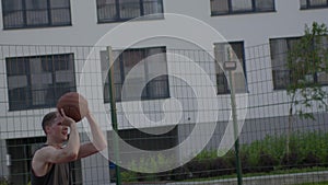 Man play in streetball at sunset urban playground