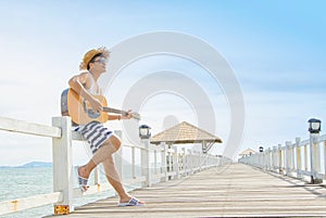 Man playing an acoustic guitar on the beach
