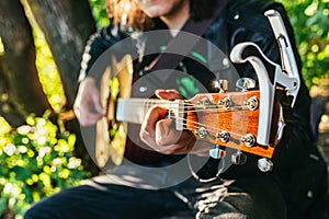 Man playing acoustic guitar and playing chords close-up
