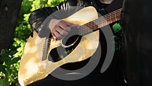 Man playing acoustic guitar and playing chords close-up