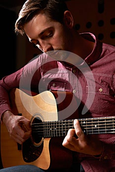 Man Playing Acoustic Guitar In Recording Studio