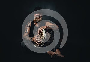 man playing an african djembe, studio photography, black background.