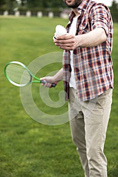 Man playing badminton on green field