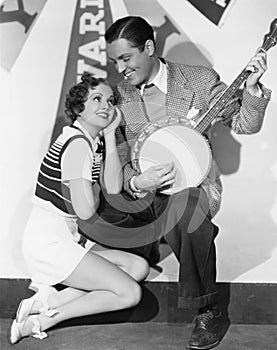 Man playing banjo for adoring woman photo