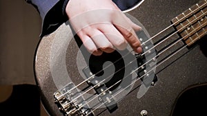 Man playing bass in slow motion. Stock. Closeup video with hands and guitar musician performs at home. Stay home